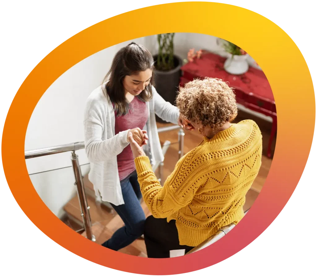 Eine Therapeutin des Therapieteams übt mit einer Klientin das Treppensteigen zuhause.