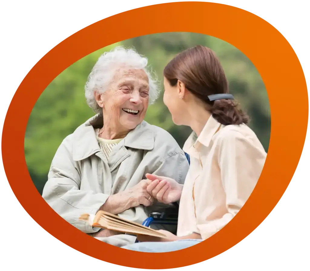 Mitarbeiterin und Klientin der Betreuungsstuben in eine angeregte Unterhaltung vertieft, die Seniorin lacht herzlich