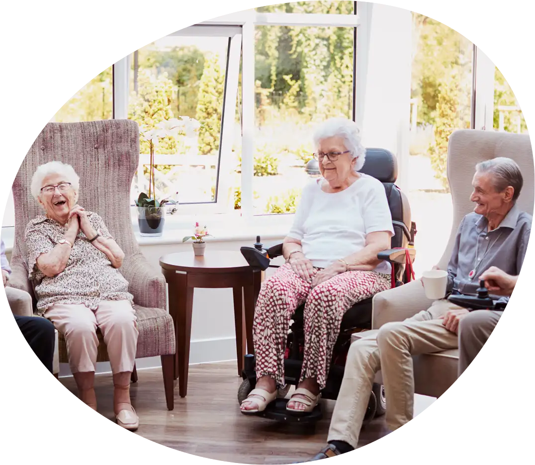 Eine Gruppe von Senioren und Seniorinnen sitzt vergnügt zusammen und lacht herzlich